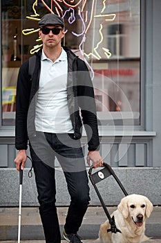 Portrait of blind man with cane for the disabled and dog on leash