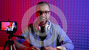 Portrait of a blogger with headphones and condenser microphone in a home studio. Male blogger recording voice over radio