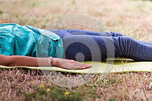 Portrait of Blond caucasian girl in Shavasana relaxation pose outdoor summer day. yoga, mindfulness, harmony concept - girl making