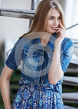 Portrait of blond female in denim jeans jacket.