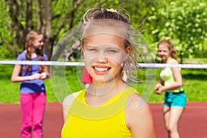 Portrait of blond girl with friends playing behind