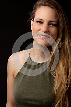 Portrait blond girl long hair black background