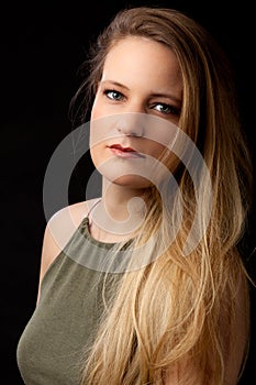 Portrait blond girl long hair black background