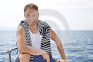 Portrait of blond handsome young man on sailing boat.