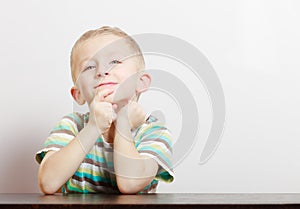 Portrait blond pensive thoughtful boy child kid at the table indoor