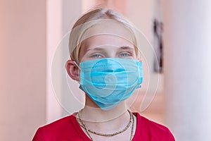 Portrait of blond teen girl in protective medical mask, coronavirus concept