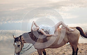 Portrait of a blond woman lying on the horse