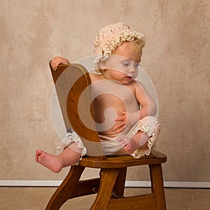 Portrait of Blonde baby on vintage chair