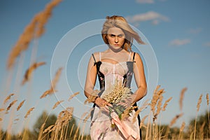 Portrait of a blonde girl in a lingerie on the field