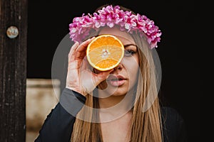 Portrait of a blonde girl with a pink wreath of flowers on her h