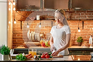 Cooking is really calming... Happy young woman cutting fresh vegetables in modern kitchen. Cozy interior