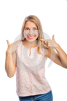 Portrait of a blonde girl who smiles and shows her teeth on her teeth, dentistry