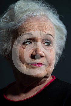 portrait of a blonde grandmother close-up on a dark background