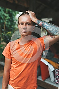 Portrait of blonde man in orange t-shirt
