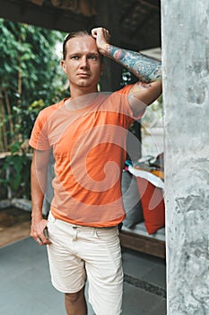 Portrait of blonde man in orange t-shirt