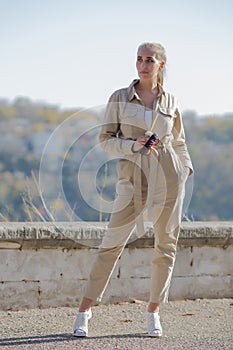 Portrait of blonde person in a jumpsuit in public Park