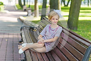 Portrait of a blonde in pink attire in a park outdoors.