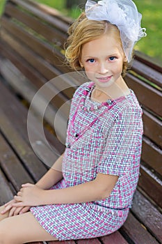 Portrait of a blonde in pink attire in a park outdoors.