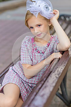 Portrait of a blonde in pink attire in a park outdoors.