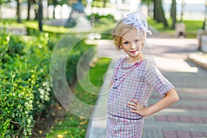 Portrait of a blonde in pink attire in a park outdoors.