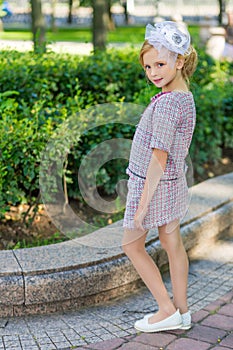 Portrait of a blonde in pink attire in a park outdoors.