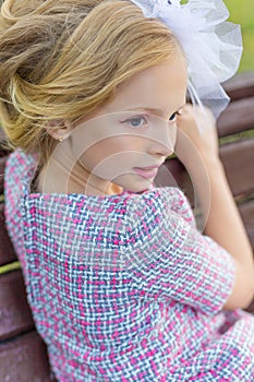 Portrait of a blonde in pink attire in a park outdoors.