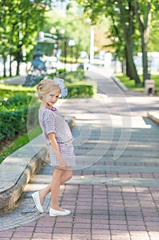 Portrait of a blonde in pink attire in a park outdoors.