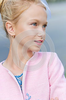 Portrait of a blonde in pink attire in a park outdoors.