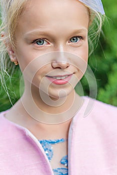 Portrait of a blonde in pink attire in a park outdoors.