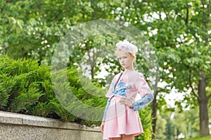 Portrait of a blonde in pink attire in a park outdoors.