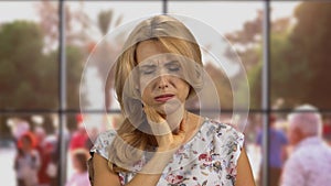 Portrait of a blonde sick woman sneezing indoors.