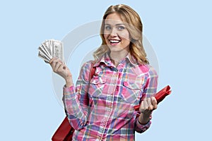 Portrait of blonde woman holding fan of dollars.