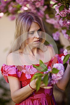 portrait of a blonde woman next to a blooming Japanese cherry tree