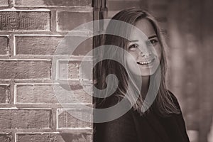 Portrait of a blonde woman in red brick hallway