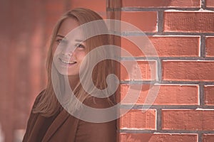 Portrait of a blonde woman in red brick hallway