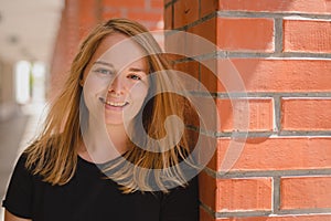 Portrait of a blonde woman in red brick hallway