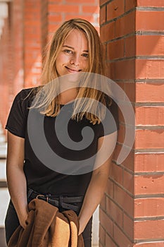 Portrait of a blonde woman in red brick hallway