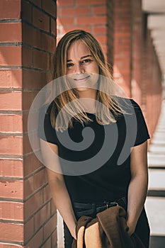 Portrait of a blonde woman in red brick hallway