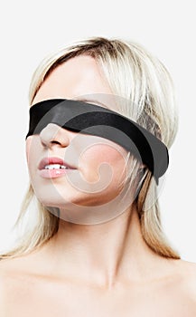 Portrait of blonde woman wearing blindfold photo