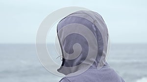 Portrait of a blue eyed woman in a jacket with a hood on a cloudy day