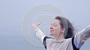 Portrait of a blue eyed woman on rain on gray rainy day at beach