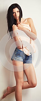 Portrait, body and woman in fashion undressing on studio white background in trendy, cool and style clothes. Attitude
