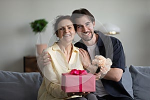 Portrait of bonding family sitting on sofa with gifts.