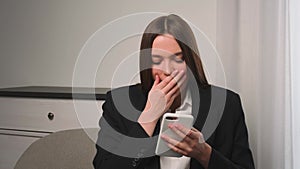 Portrait of a bored attractive young woman using her phone for online shopping in social media, woman yawns, typing on