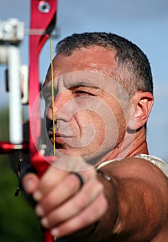 Portrait of bowman aiming with bow and arrow photo