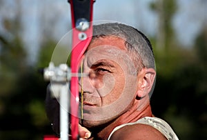 Portrait of bowman aiming with bow and arrow photo