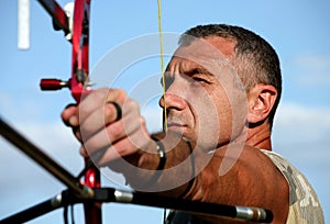 Portrait of bowman aiming with bow and arrow photo