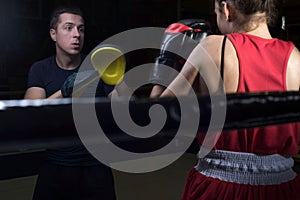 Portrait of a boxing trainer guy training a young athlete training her in martial arts. In a boxing club. Girls learn self-defense