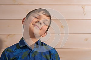 Portrait of a boy 8 years old brunette in a blue shirt. Depicts a dream while standing