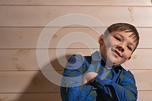 Portrait of a boy 8 years old brunette in a blue shirt. He folded his hands
